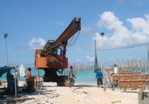 Piling rig installing precast piles on a beach site