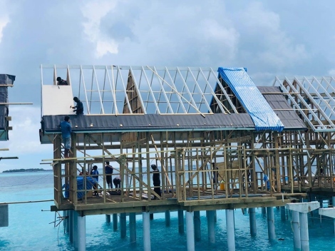 Overwater villa frame under construction above a lagoon
