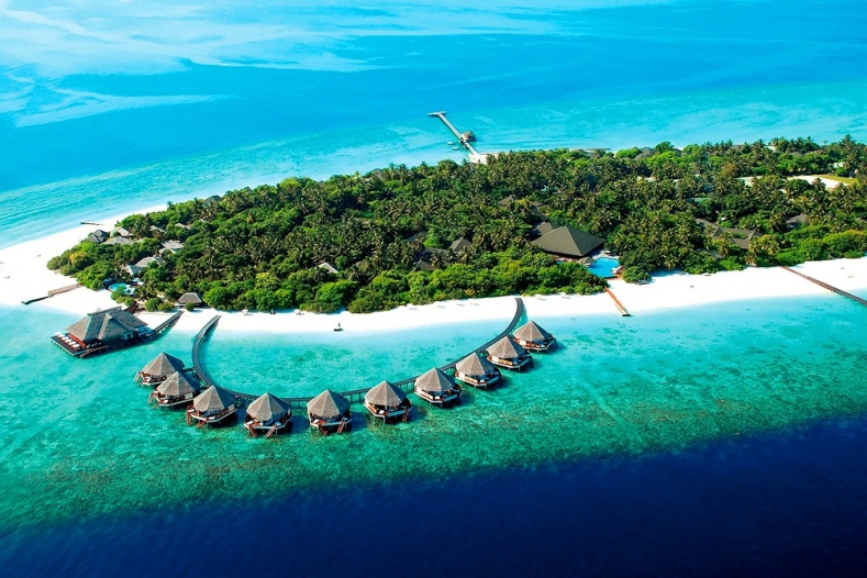 Aerial view of a resort island with a line of water villas, illustrative