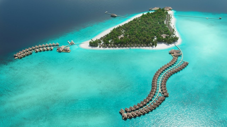 Aerial view of a resort island with overwater villa jetties, illustrative